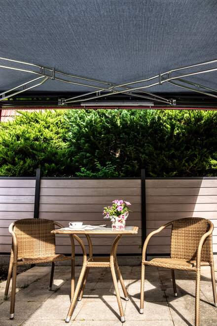 [Translate to English:] Markise spendet Sonnenschutz auf der Terrasse